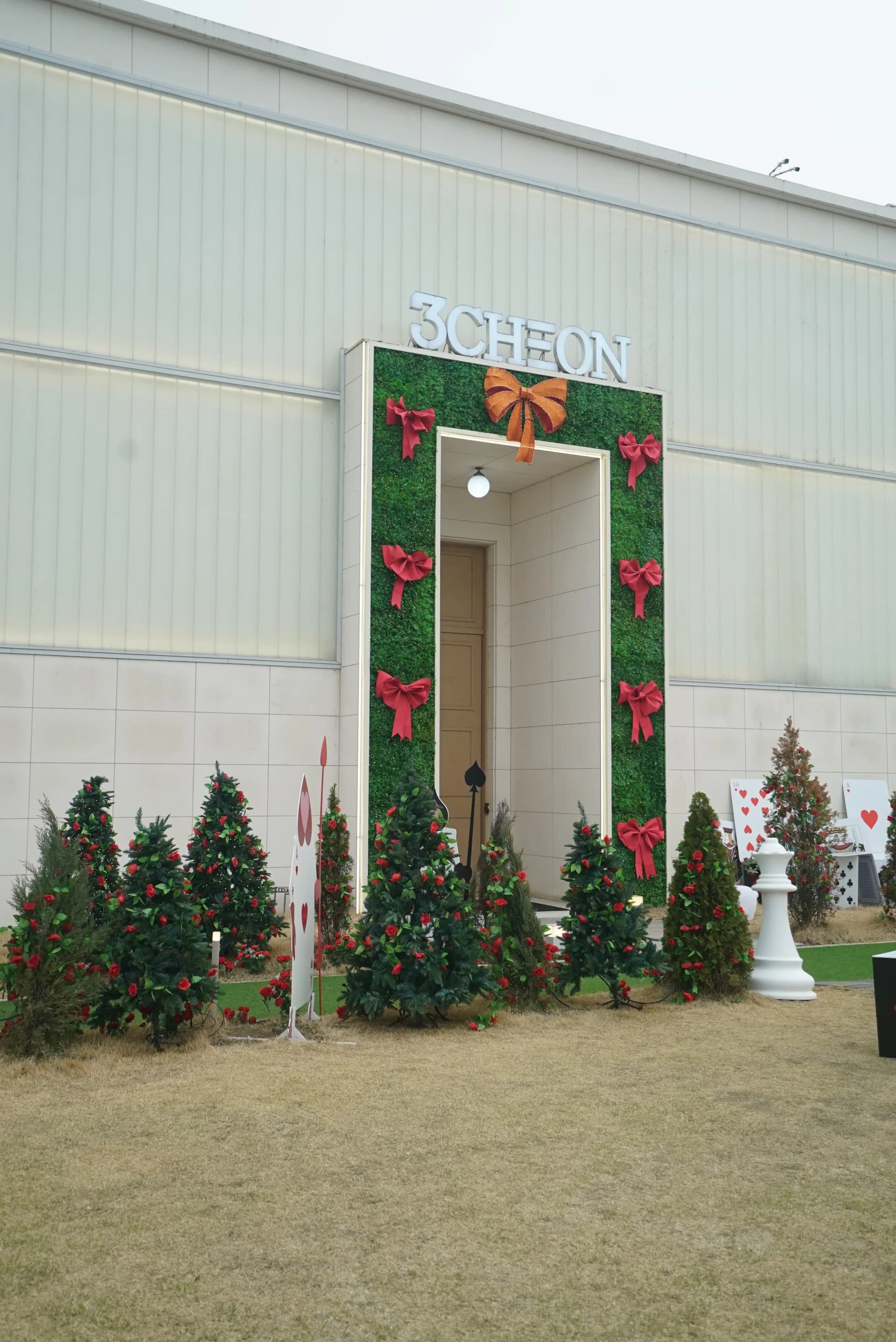 3Cheon Village themed cafe entrance with a grass-covered gate and festive decorations in Jeonju