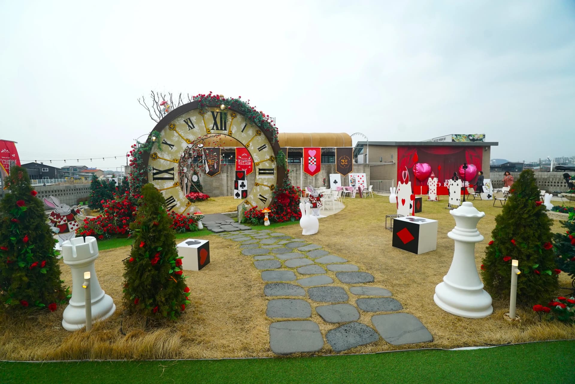 Rooftop garden panorama with giant clock sculpture and Alice in Wonderland themed decorations at this instagrammable cafe