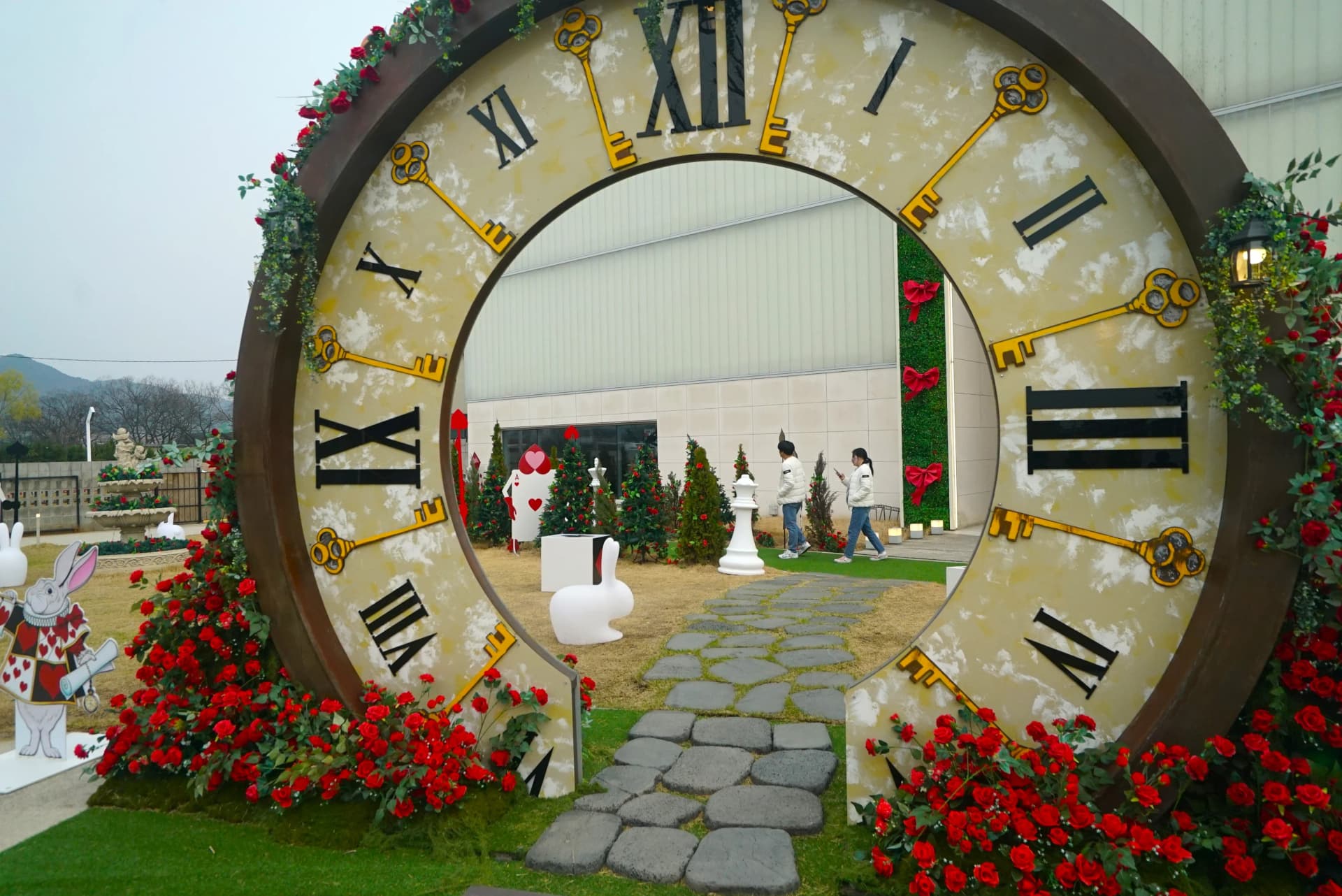 Walk-through clock sculpture decorated with roses and golden key charms at the garden cafe