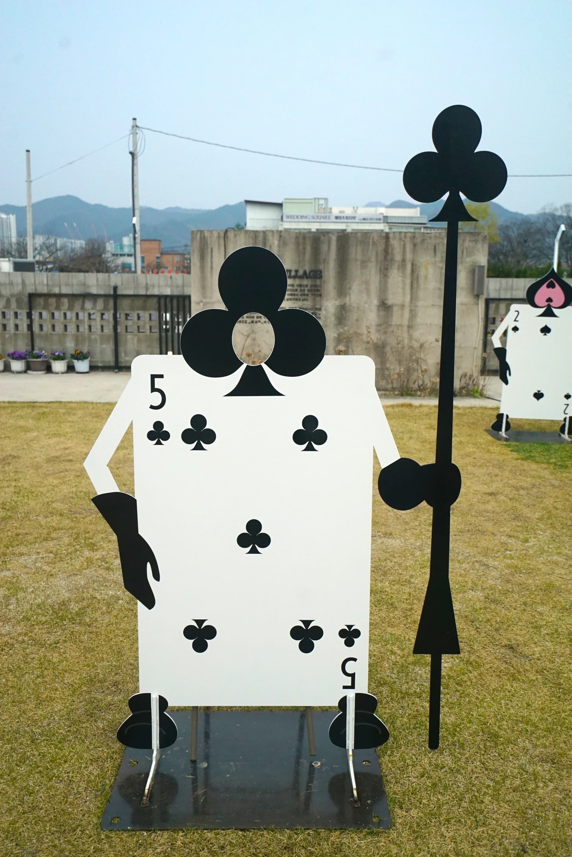 Playing card soldiers — clubs and diamonds — lined up as themed photo spot sculptures
