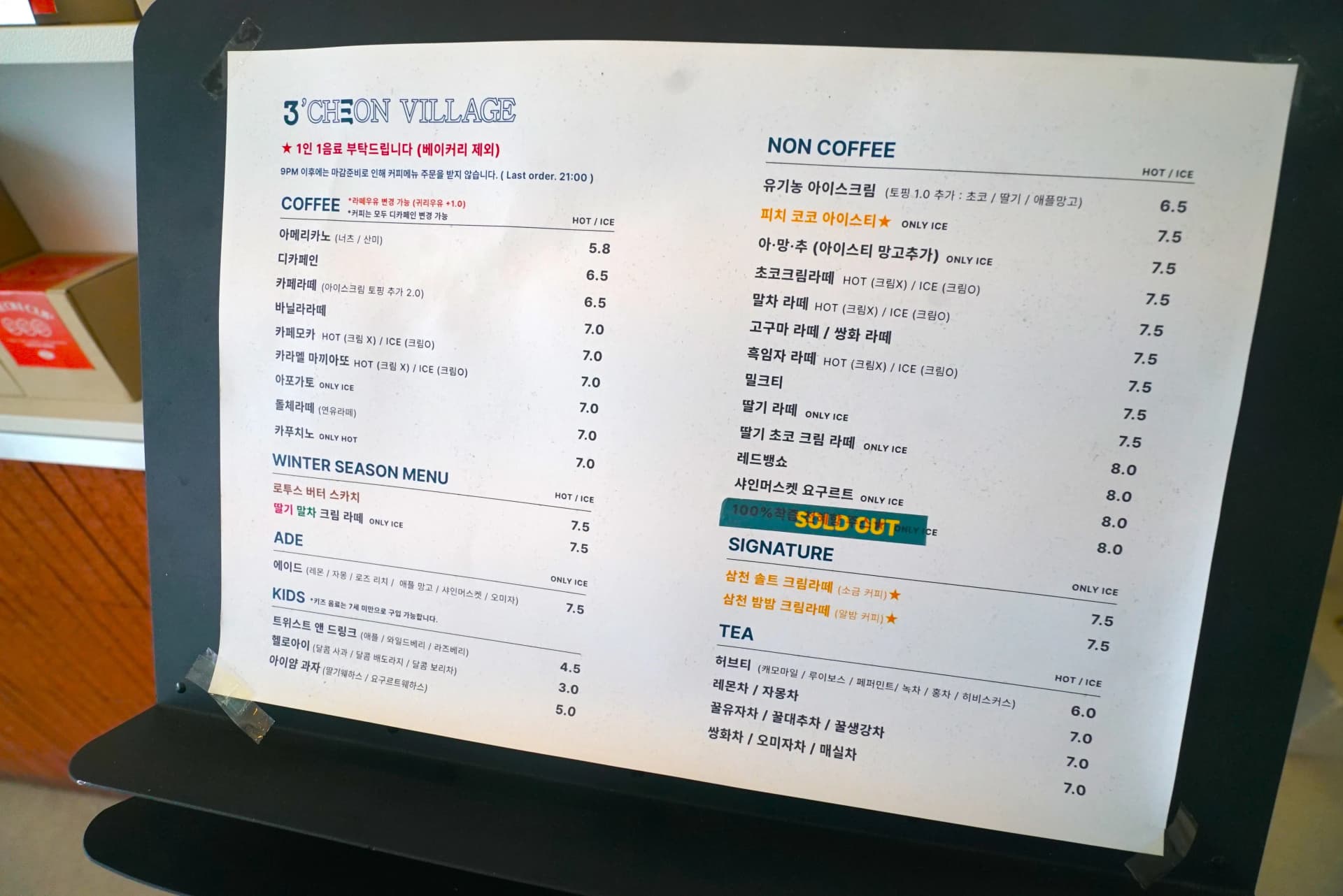 Paper menu showing coffee, non-coffee, signature and tea options with prices at 3Cheon Village cafe
