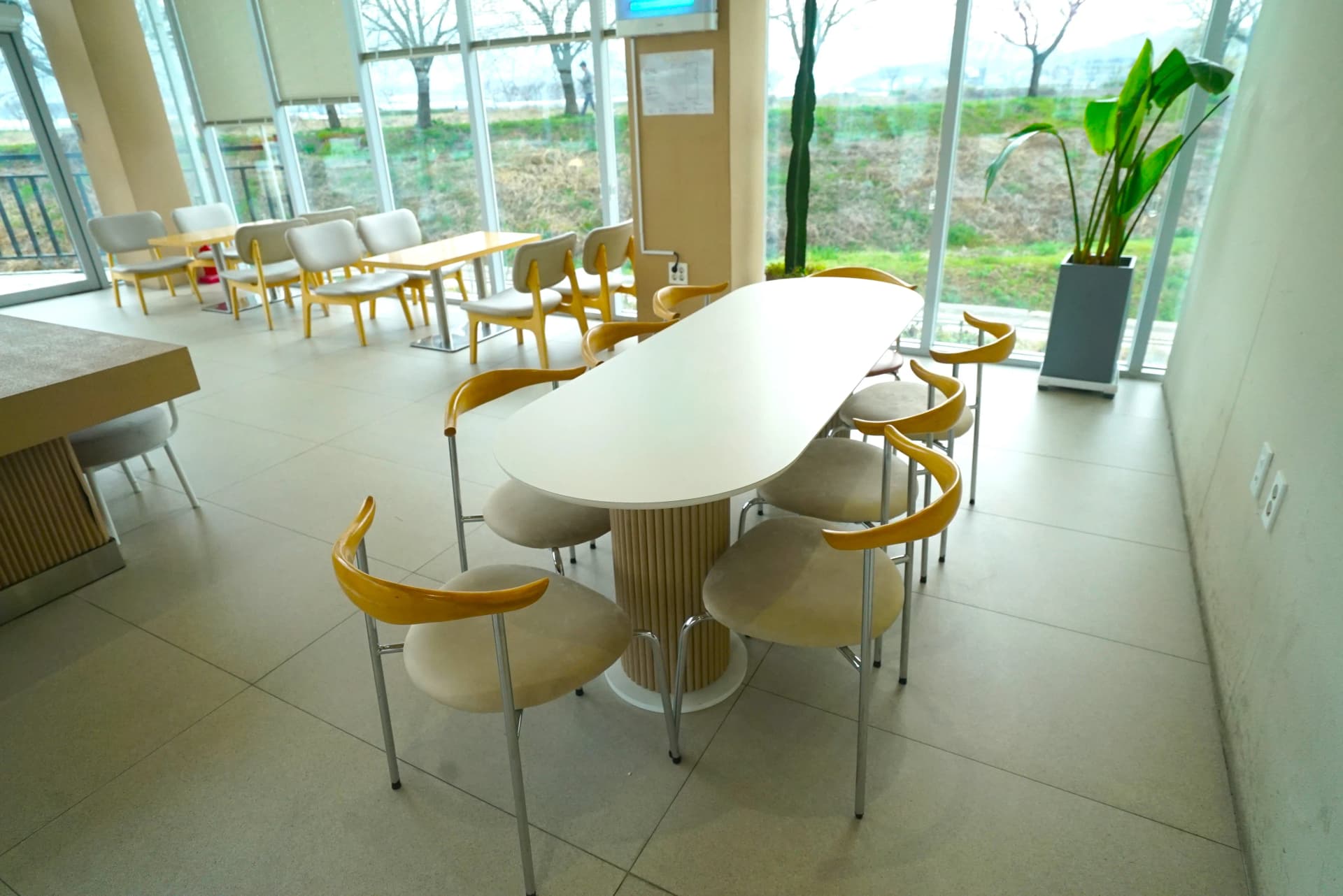 Stone table with pink flower pots as interior decor on the ground floor of 3Cheon Village cafe