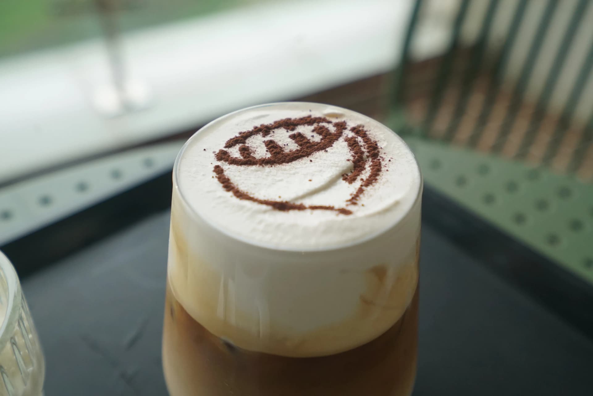 Bam Bam Cream Latte close-up with cocoa powder smiley face drawn on the cream top