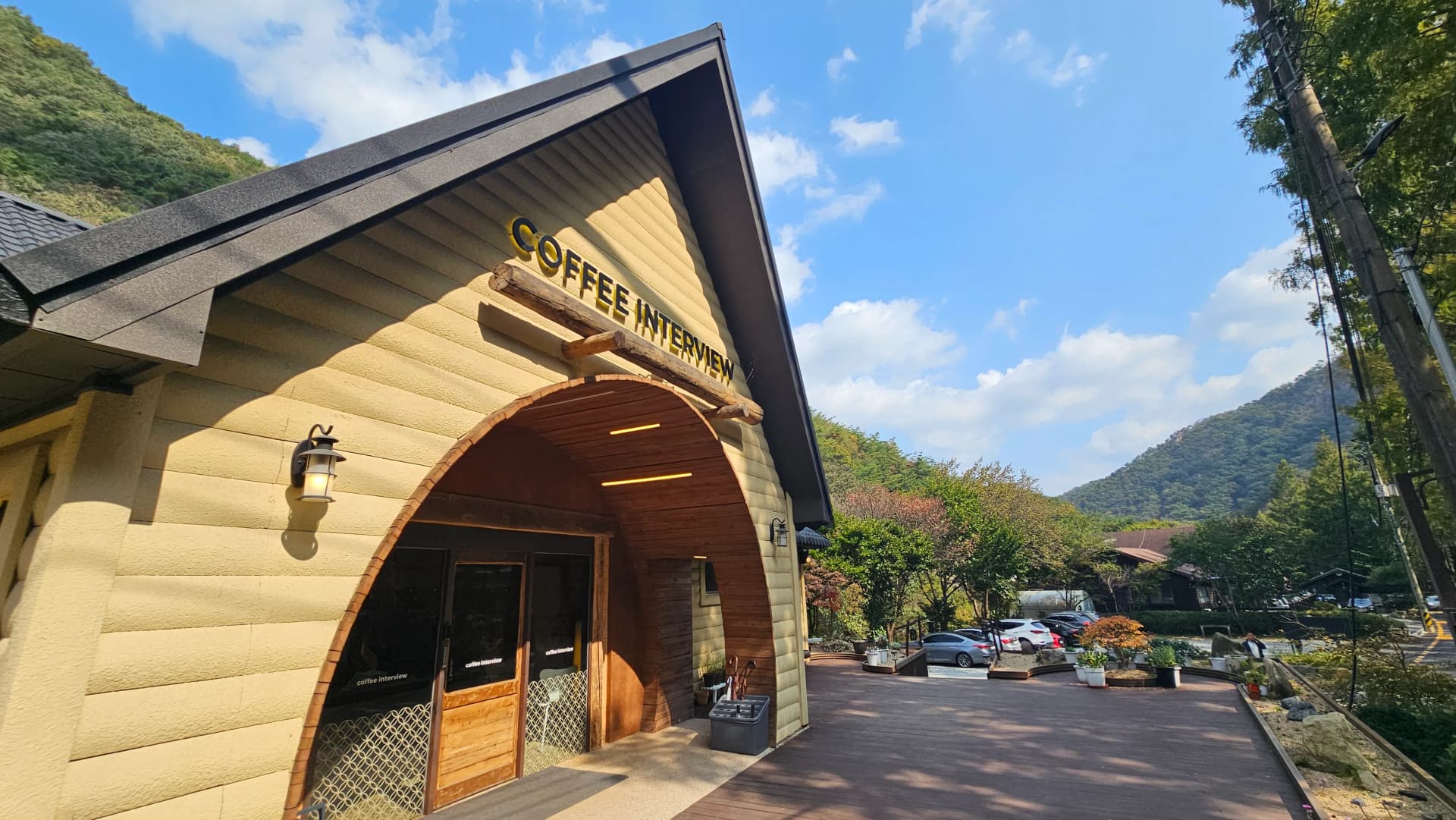 کافی انٹرویو جانگ ٹیسان کا محرابی دروازہ، لکڑی کے ستون اور نام کا سائن بورڈ