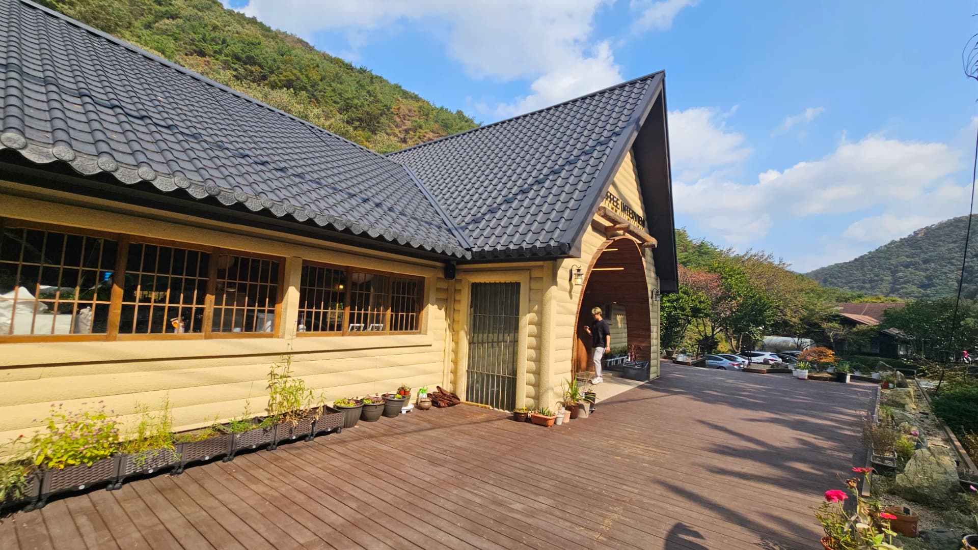 کیفے کی سائیڈ ویو، لکڑی کی دیوار، جالی دار کھڑکیاں اور چوڑا ڈیک