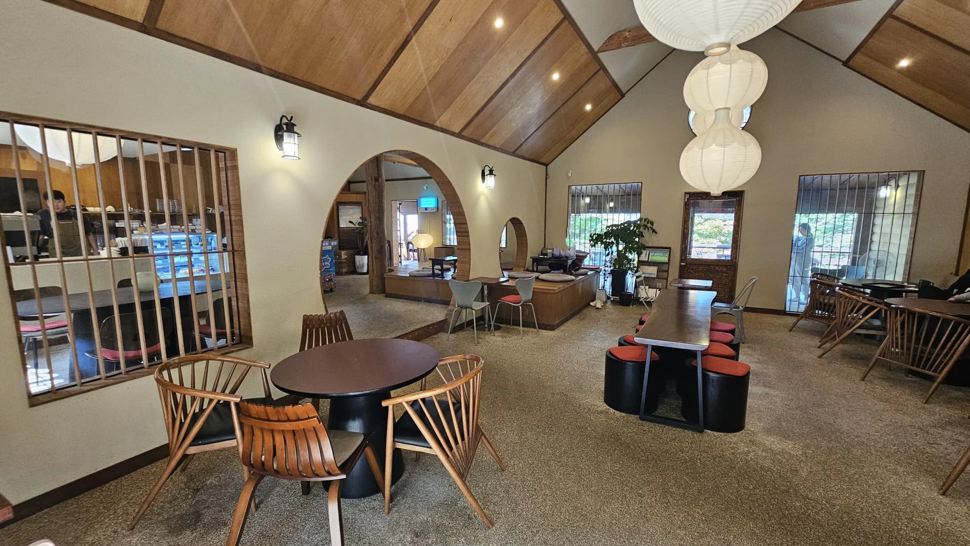 جنگل کیفے کا اندرونی منظر، تکونی اونچی چھت اور بھورے لکڑی کے انٹیریئر کے ساتھ