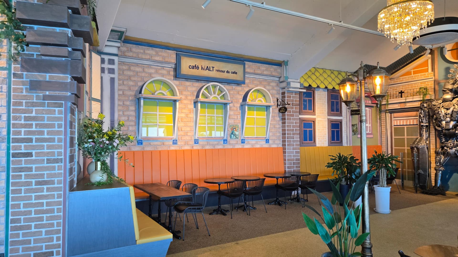 더킹 카페 유럽풍 벽면 오렌지 노랑 벨벳 소파 좌석 - 가짜 창문 가로등 인테리어 - The King Cafe European wall with orange and yellow velvet sofas and faux windows | 하이제이에스비