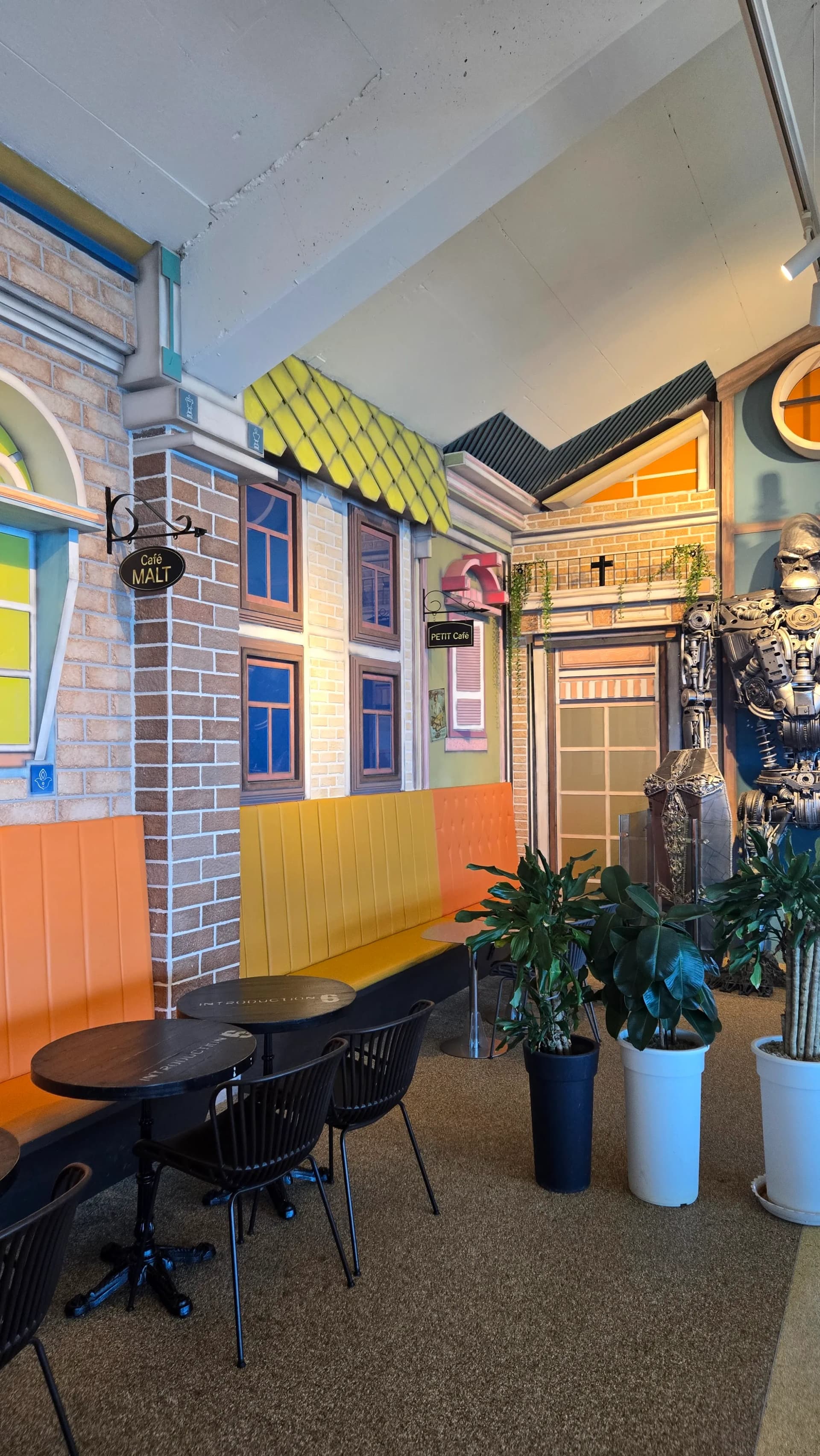 더킹 카페 컬러풀한 건물 파사드 인테리어 - 금속 조형물과 덩굴 장식 테마파크 분위기 - The King Cafe colorful building facade interior with metal sculptures and vine decorations | 하이제이에스비