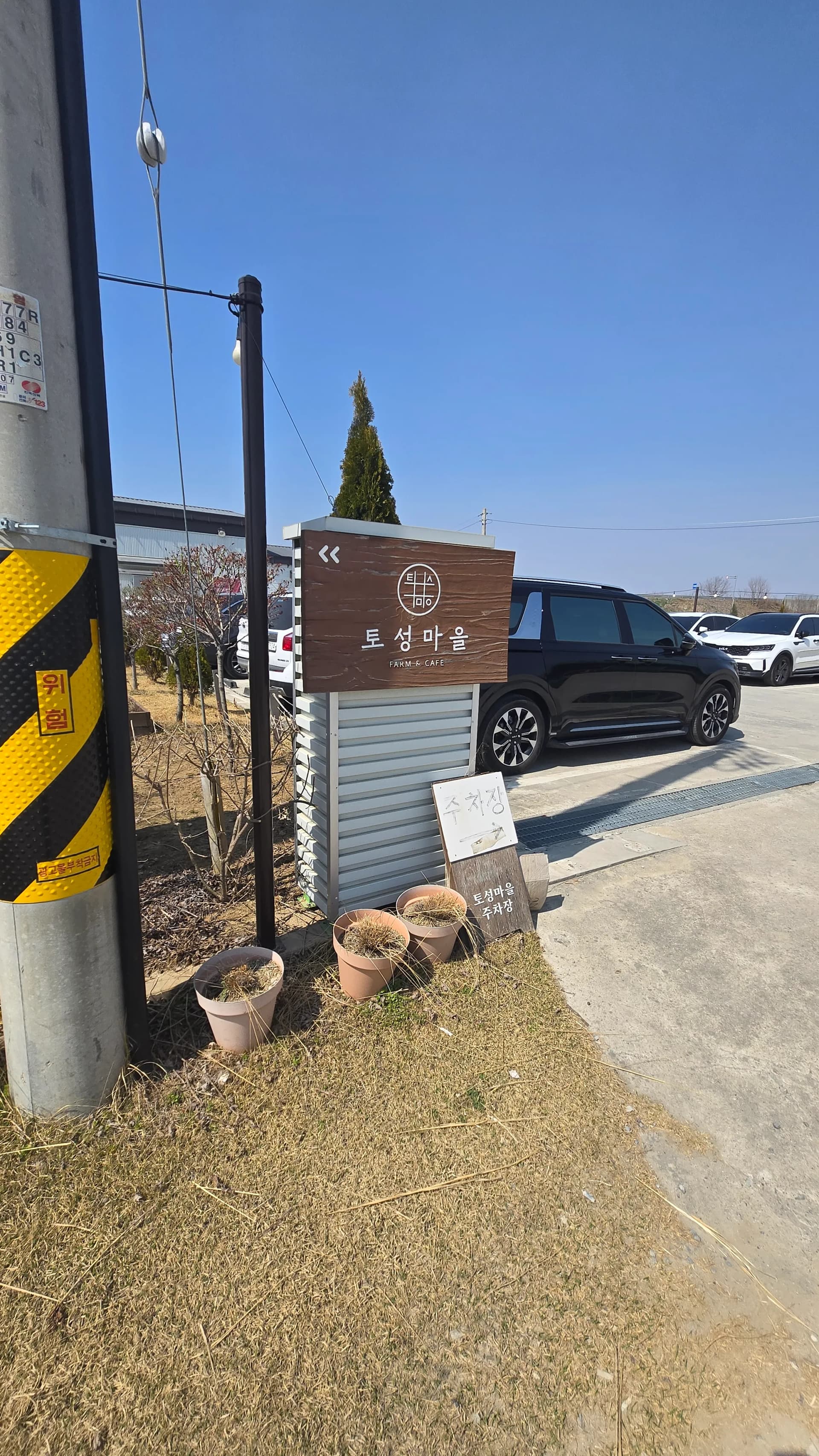 Wooden sign at the entrance to Toseong Village and the main car park area