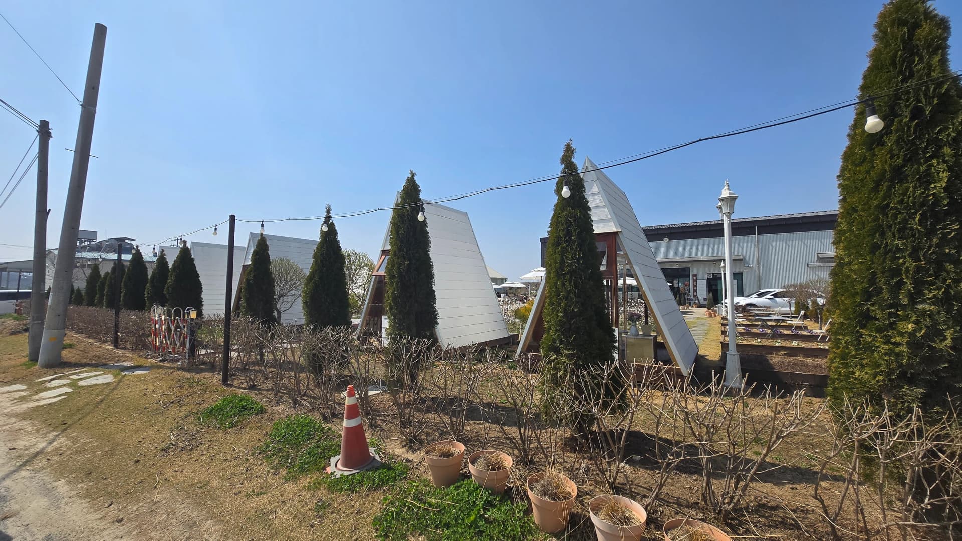 Close-up of A-frame cabin with cypress trees planted between each cabin for natural privacy