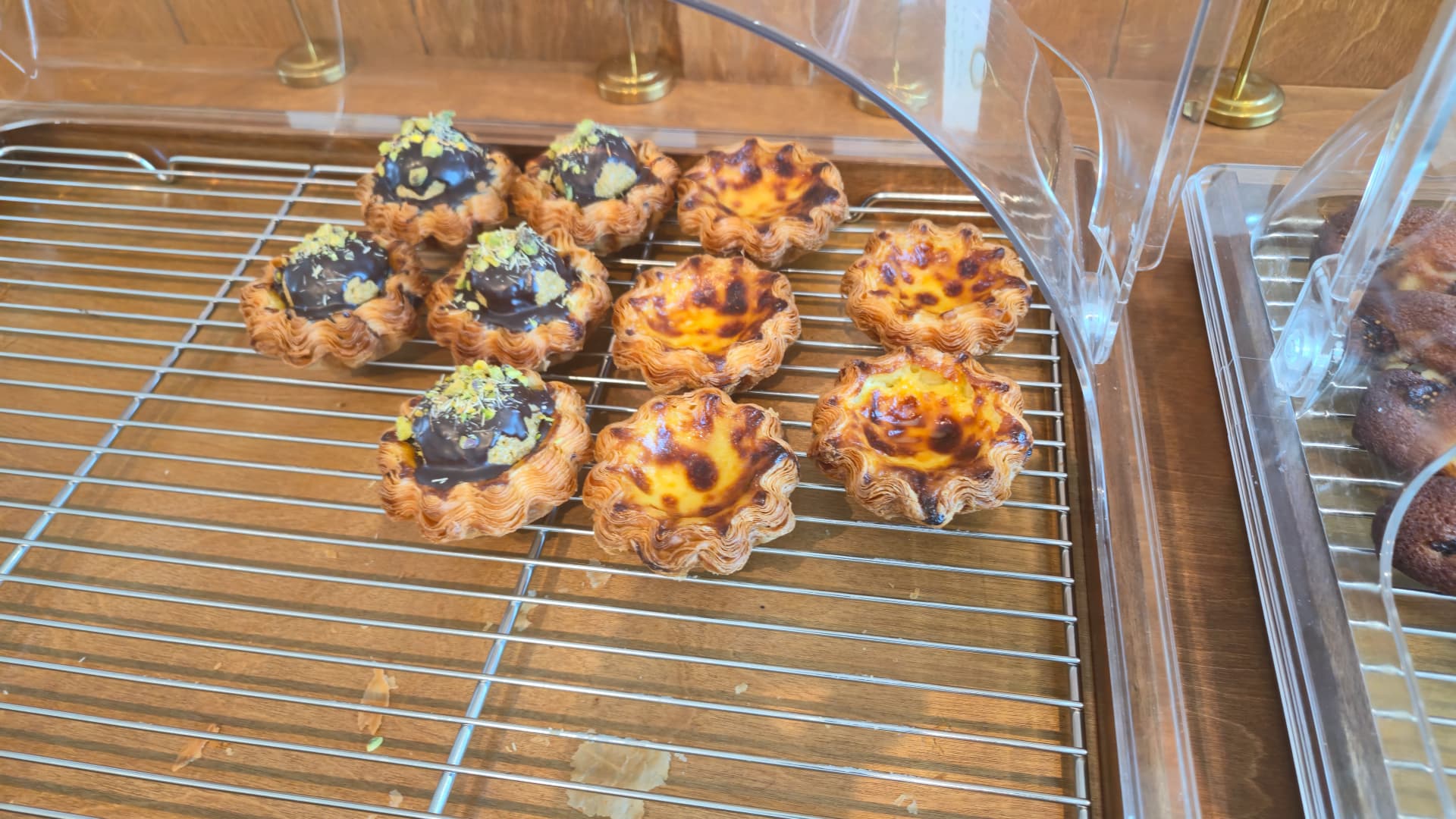 Caramelised egg tart and chocolate tart dusted with pistachio at the Toseong Village bakery display