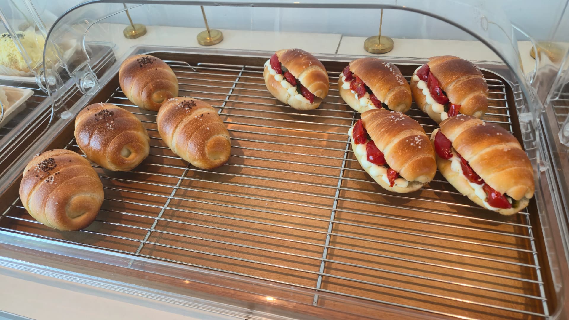 Black sesame salt bread and strawberry cream salt bread side by side on a single tray