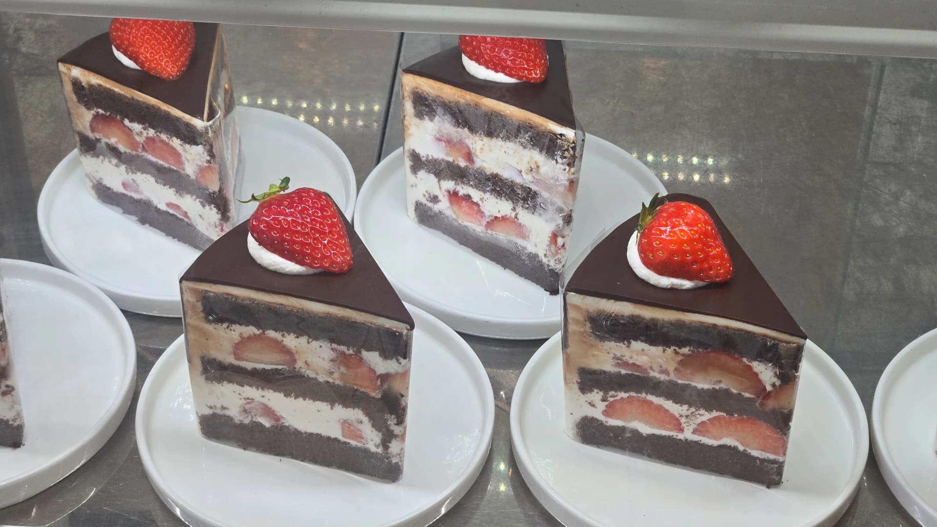Slices of chocolate strawberry cake in the refrigerated showcase at Toseong Village