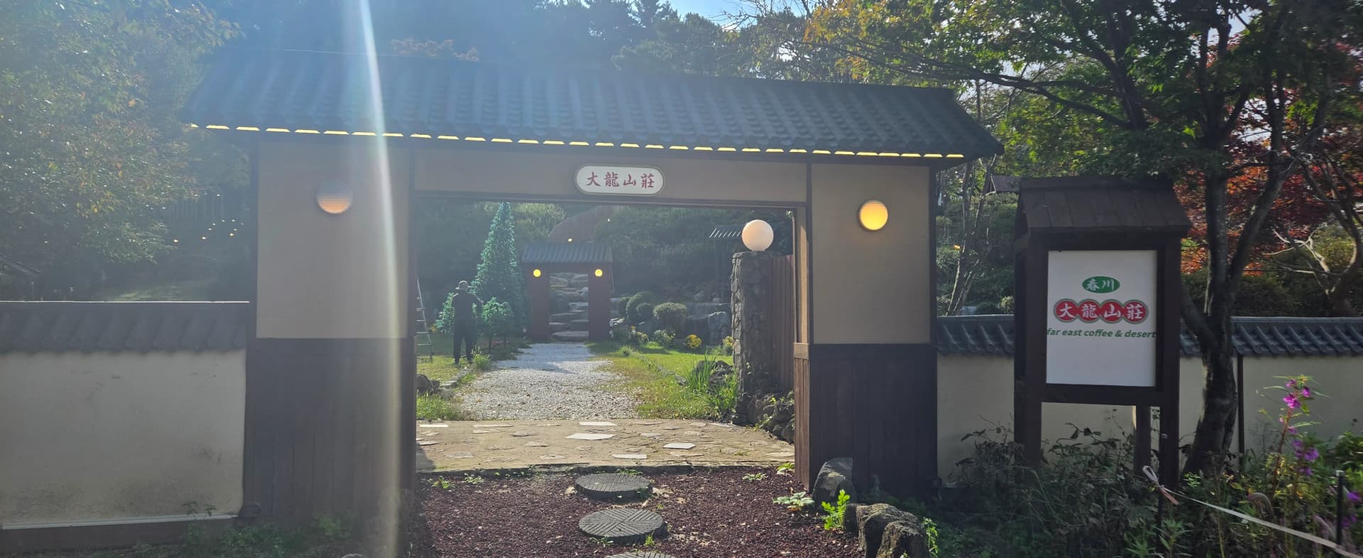 Close-up gerbang utama Daeryong Sanjang, papan tanda aksara Cina dan papan makluman kopi serta pencuci mulut gaya Timur | 하이제이에스비