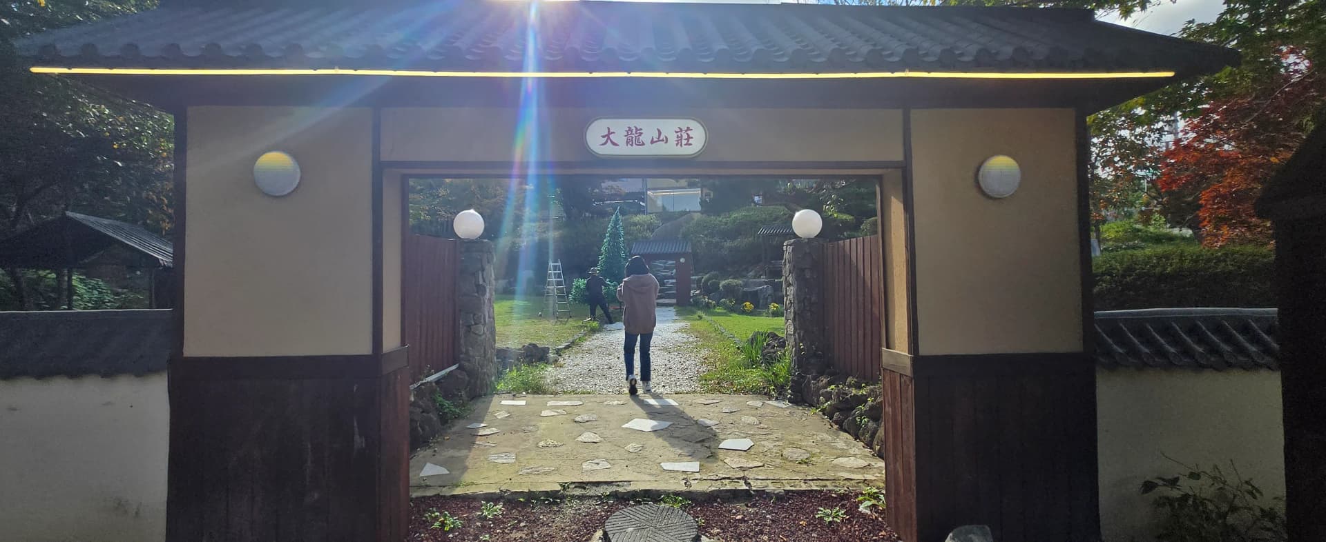 Melalui gerbang Daeryong Sanjang, laluan batu menuju taman dan rumput hijau di hadapan | 하이제이에스비