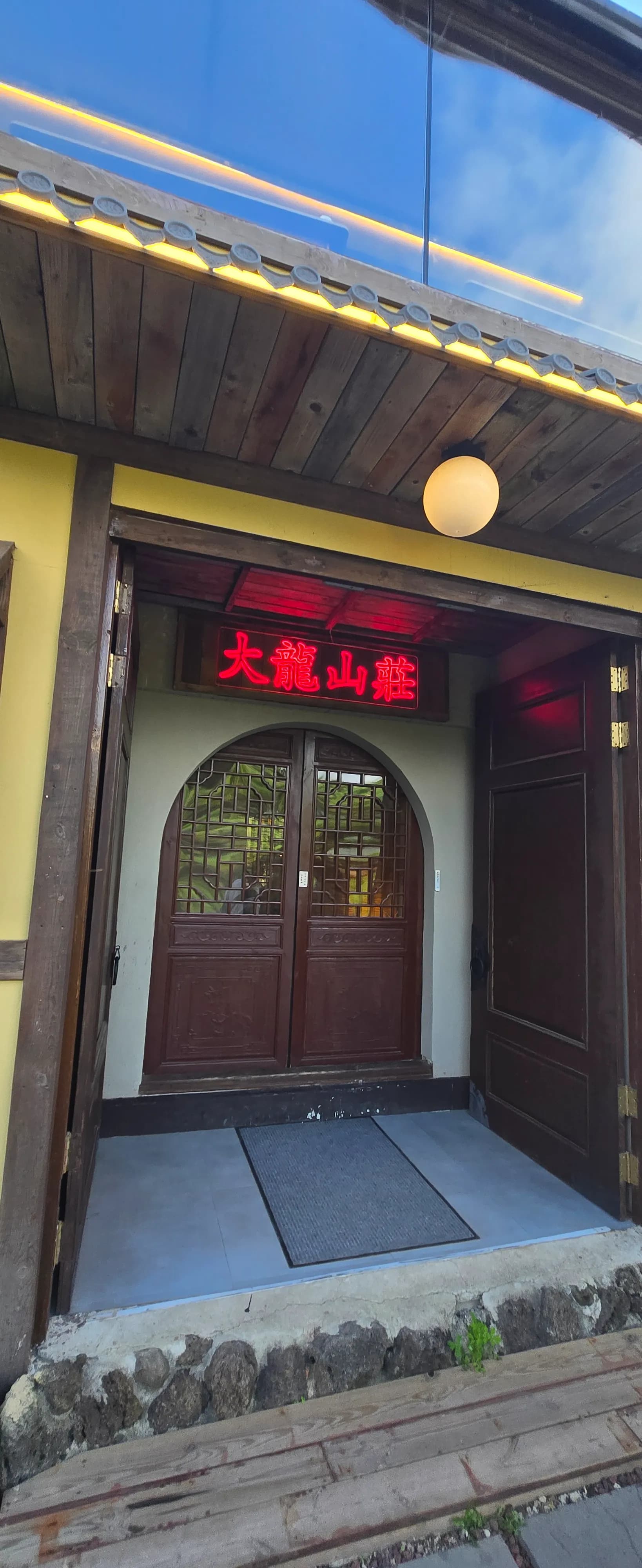 Pintu masuk kafe Daeryong Sanjang, papan neon merah dan pintu kayu berlengkung bercorak kisi gaya Jepun | 하이제이에스비