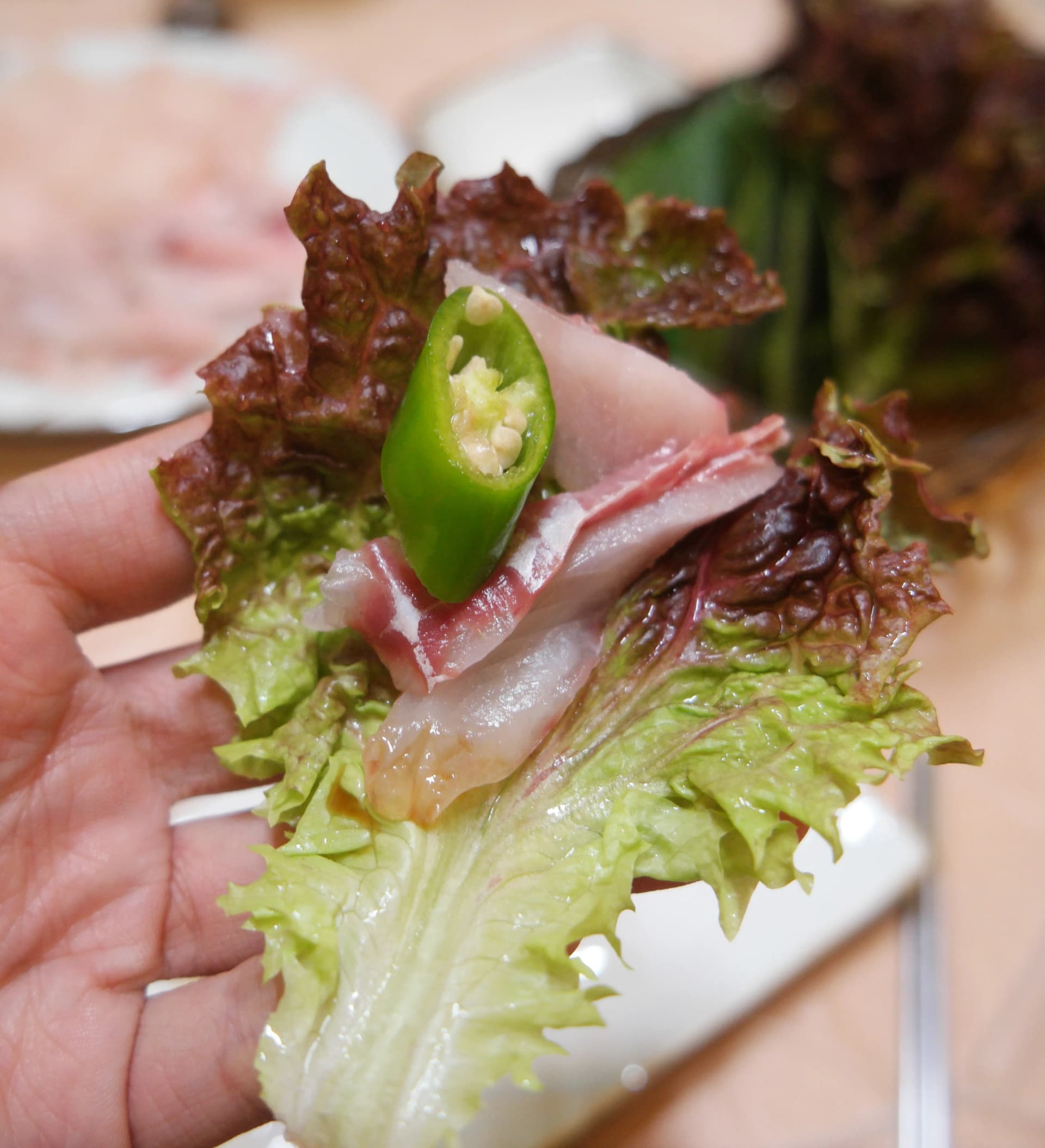 상추 위에 회 한 점, 마늘, 청양고추를 올려 쌈으로 싸 먹는 한국식 회 먹는 방법 | 하이제이에스비