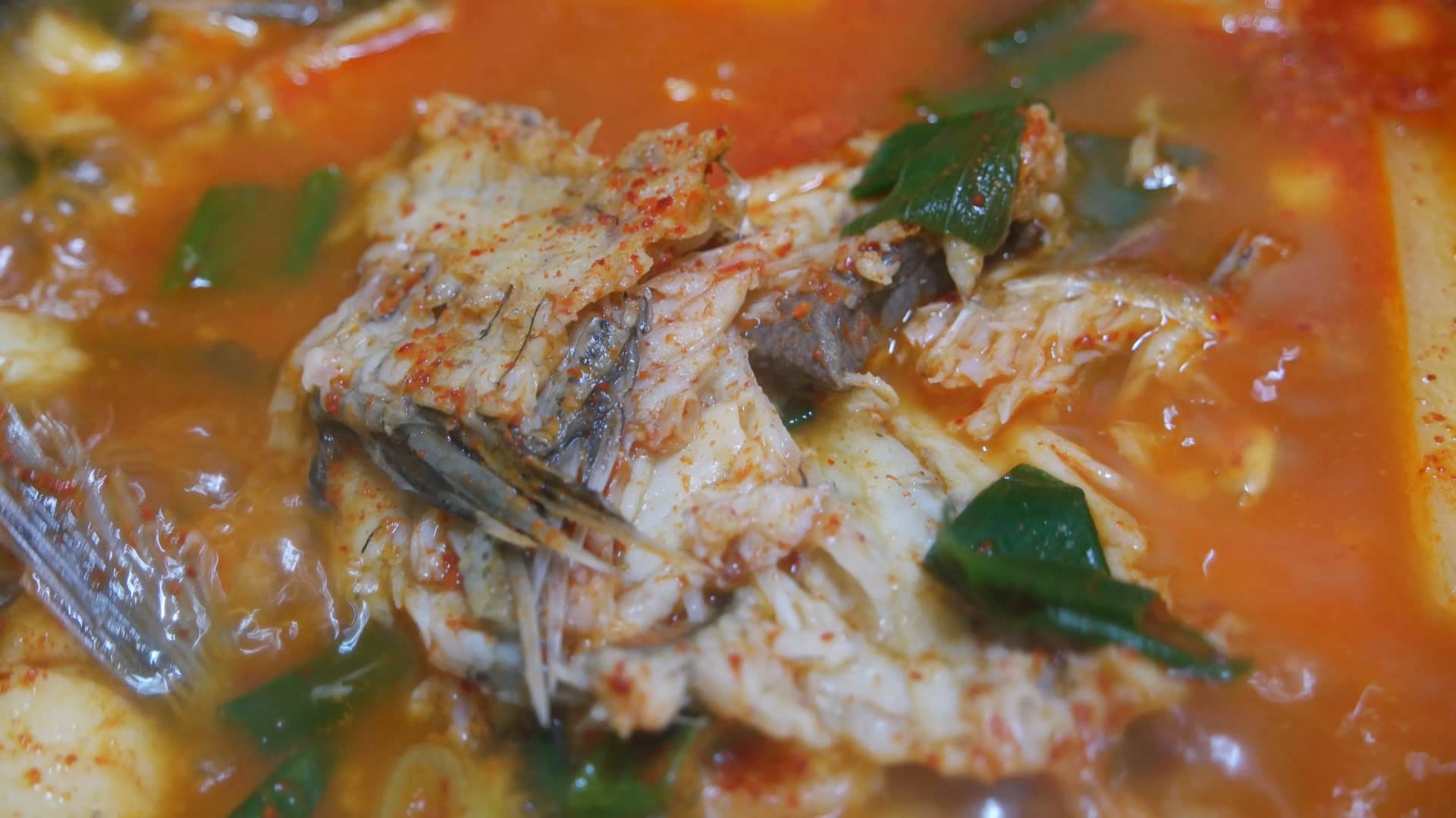 국자로 퍼올린 매운탕 - 생선 뼈와 자투리 살이 붉은 국물 안에 푹 익어있다 | 하이제이에스비