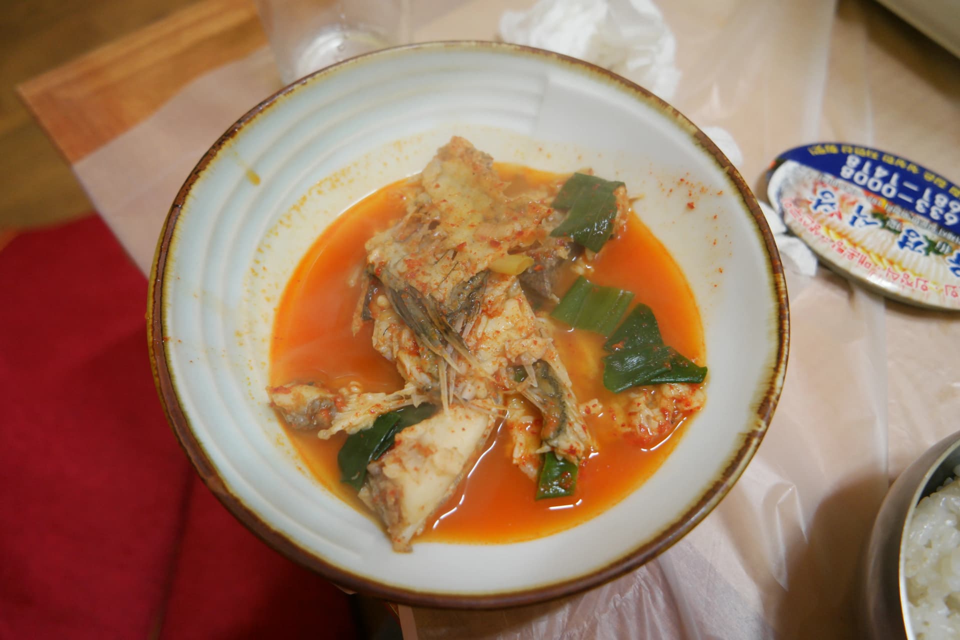 그릇에 담은 매운탕 한 그릇 - 붉은 국물에 생선 살점이 듬뿍 담겨있다 | 하이제이에스비