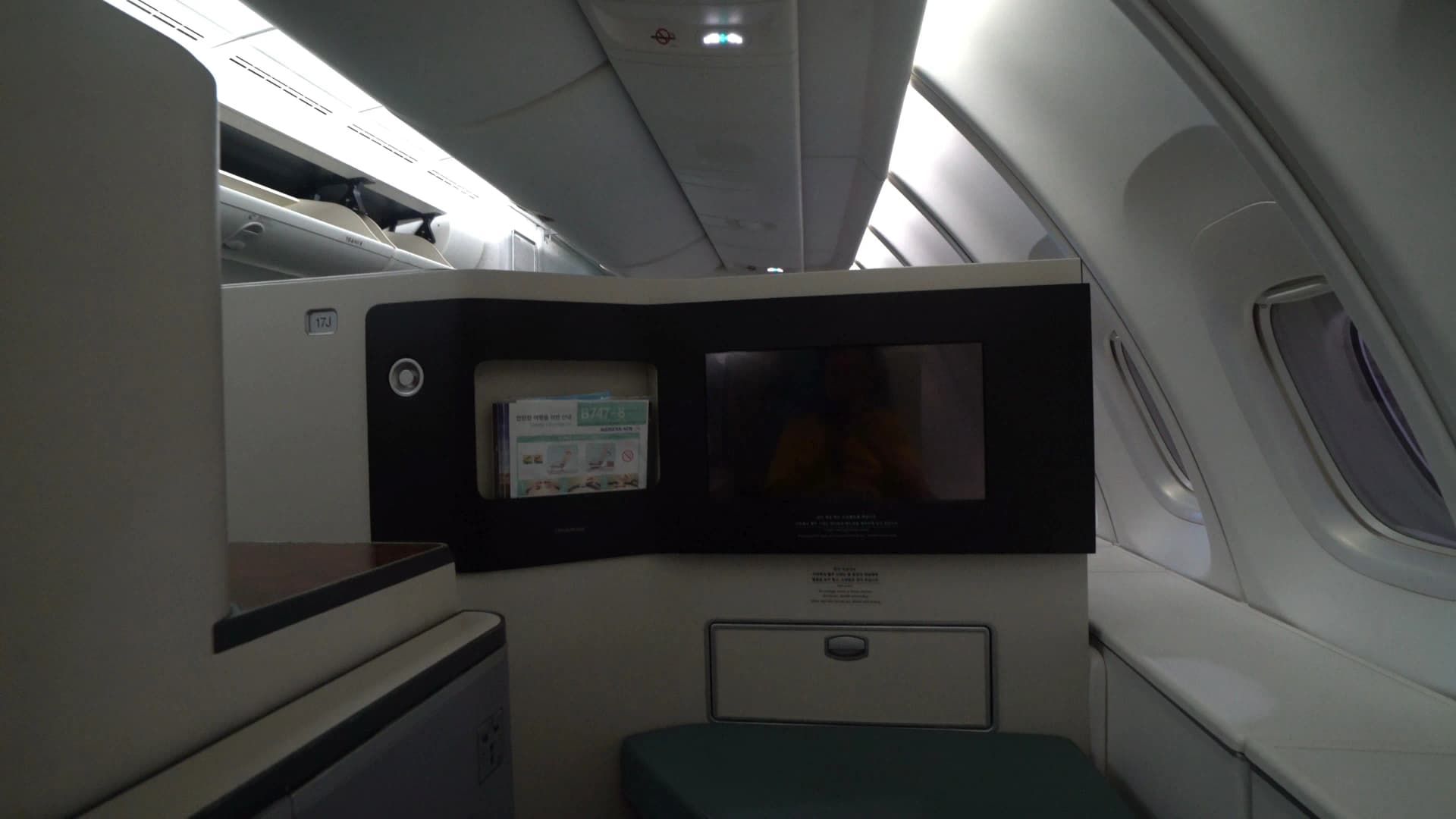 Corridor through Korean Air 747-8i main deck Prestige Class section toward the iconic upper deck staircase