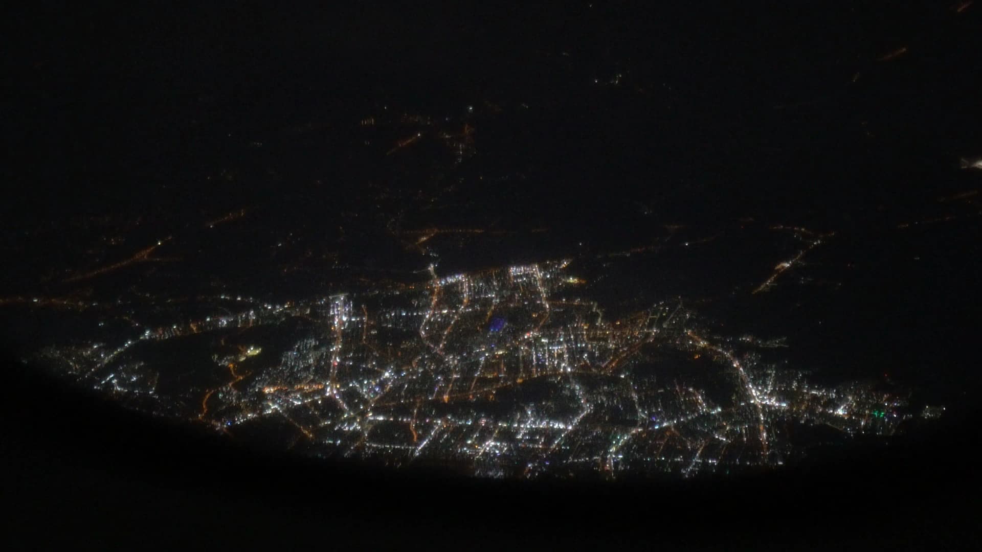 Night city lights of Korea visible through Korean Air 747-8i window on approach to Incheon Airport