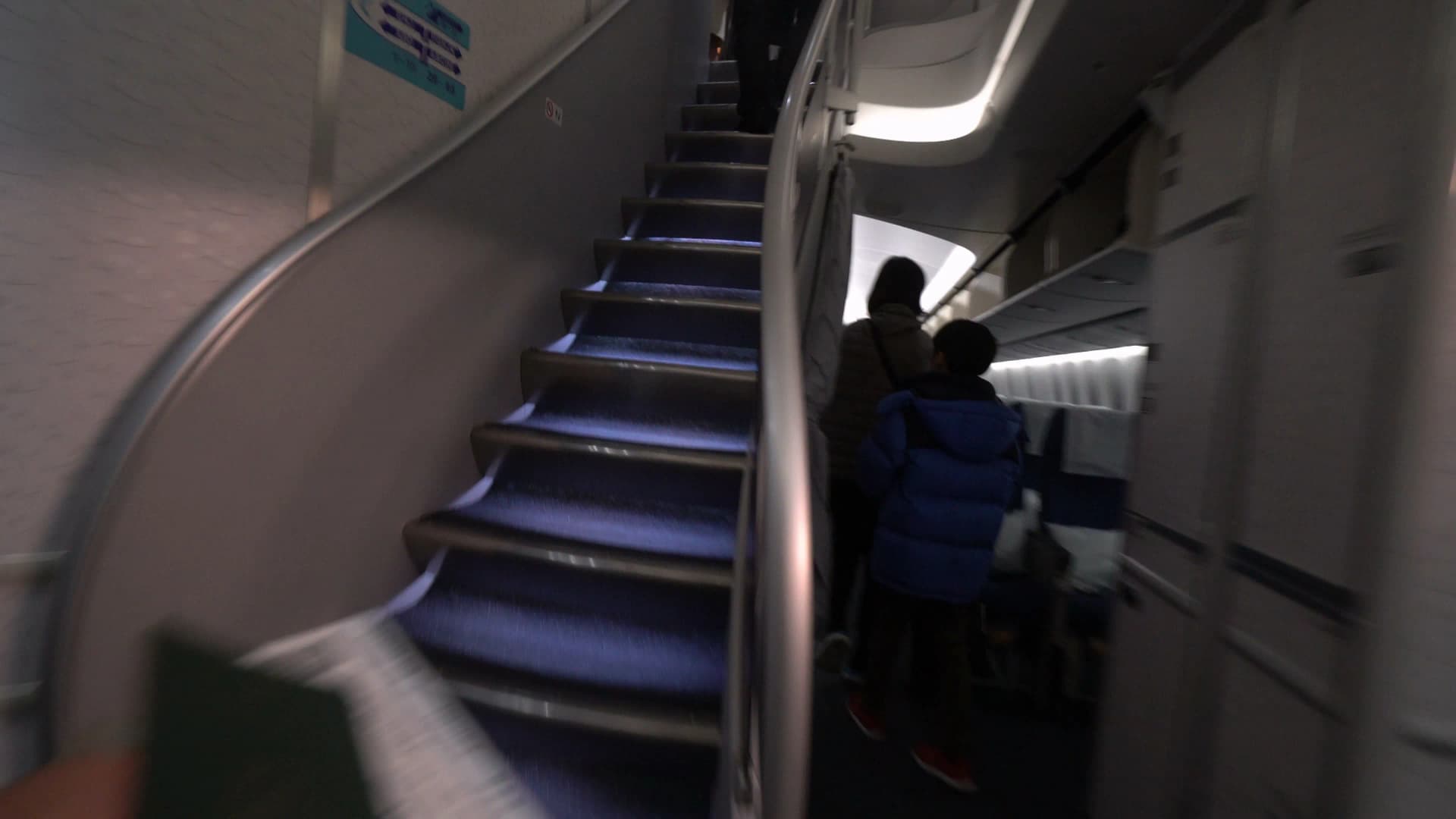 Walkway through Korean Air 747-8i main deck Prestige Class cabin leading to the upper deck staircase
